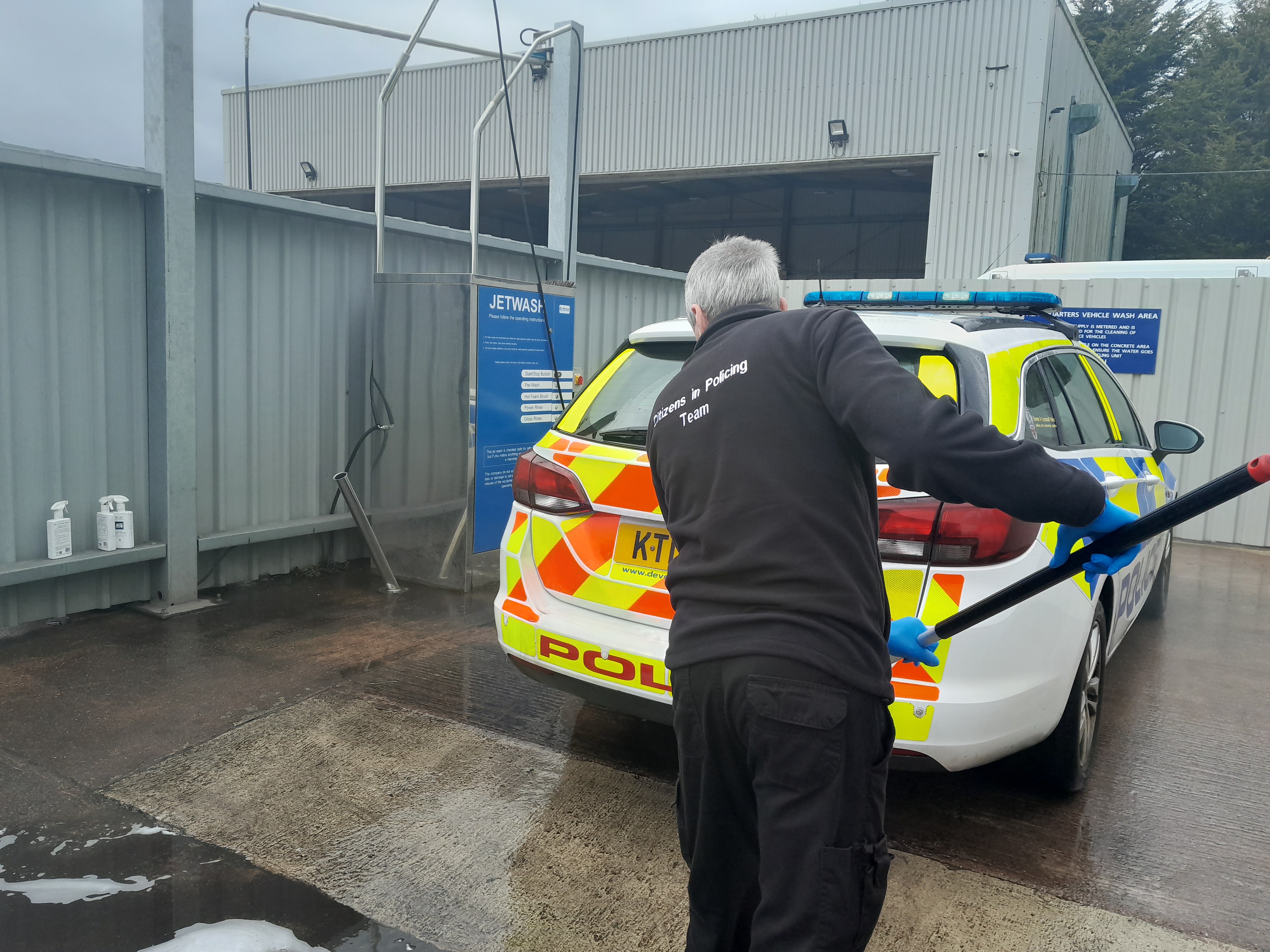 Showing the back of Steve as he checks a police car.