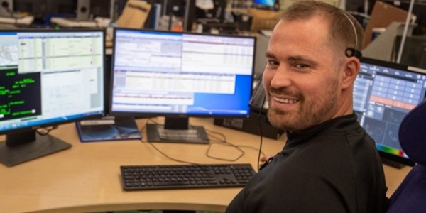 Call handler at desk facing camera and smiling