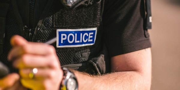 Close up of police office torso and hand writing to a note book