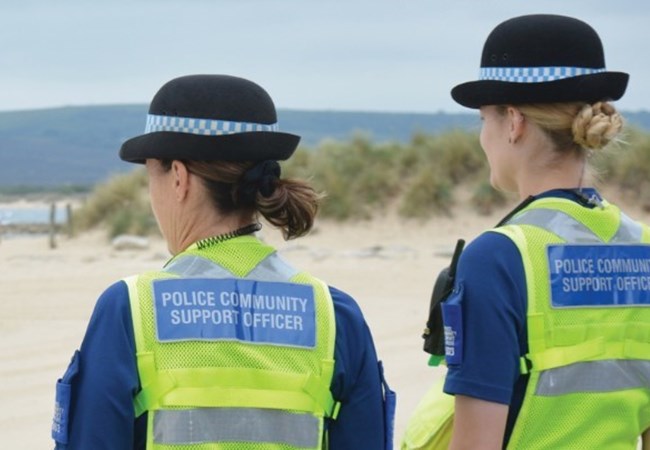 Two PSCO's looking at a sandy beach on a fine summers day
