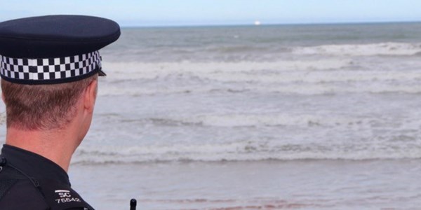 A Police Officer looking out to sea