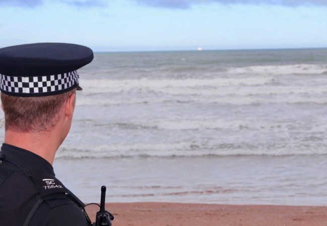 A police officer looking out to sea